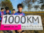 Student holding 1000KM Beijing to Hong Kong sign.